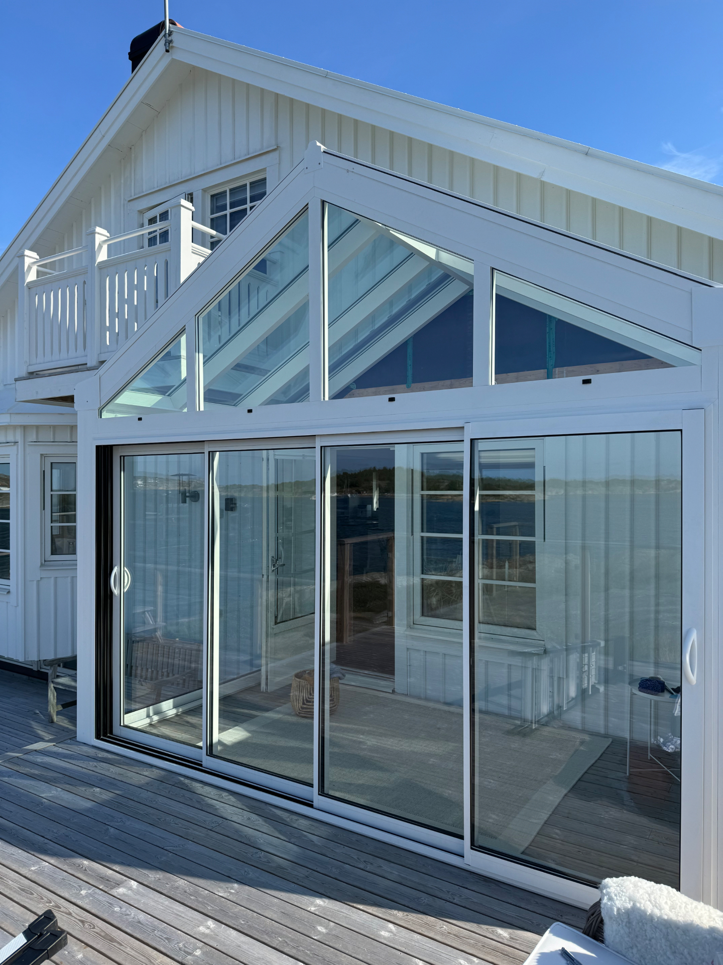 Vitt aluminiumuterum med Infinity skjutpartier mot havet