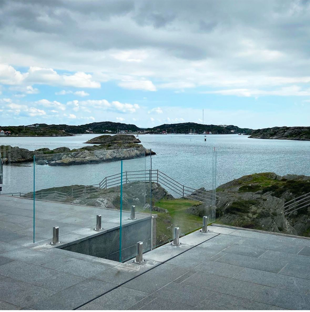 Glasräcke med diskreta beslag på terrass med havsutsikt